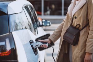 A flat lay featuring a laptop, a premium blue credit card, and colorful shopping bags suggests online purchases. The image subtly represents how credit cards with fuel rewards are impacting the electric car market in the US by incentivizing fuel-based spending, potentially influencing consumer preferences and delaying the adoption of electric vehicles.