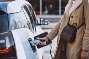 A flat lay featuring a laptop, a premium blue credit card, and colorful shopping bags suggests online purchases. The image subtly represents how credit cards with fuel rewards are impacting the electric car market in the US by incentivizing fuel-based spending, potentially influencing consumer preferences and delaying the adoption of electric vehicles.