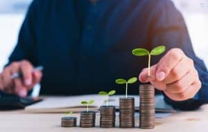 Stacks of coins with small plants growing on top, symbolising sustainable growth and investment opportunities supported by commercial loans.